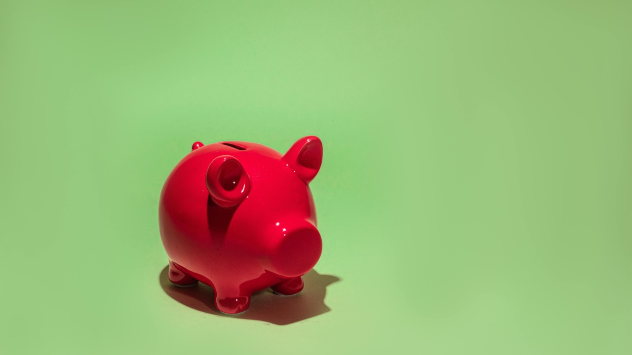 Red piggy bank on a green background symbolizing financial management and revenue generation for nonprofit associations.
