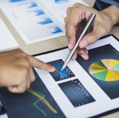 Hands analyzing data charts and graphs on a clipboard, emphasizing strategic planning and performance metrics for associations.